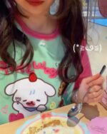 A person wearing a lolita aesthetic tee featuring cute character designs.