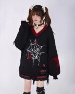 Black loose gothic sweater with spider and skull embroidery, layered with a v-neck cardigan.