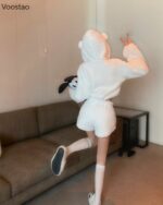 Woman wearing white bear pajamas, kawaii style, fluffy hooded sweatshirt and shorts.