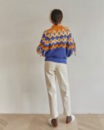 Back view of a blue and orange kawaii winter sweater with fringe details.