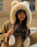Thick fluffy bear ears hat worn by a woman on a winter day.