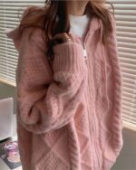 Pastel hooded sweater in soft, textured knit, featuring a relaxed fit and zipper closure.