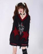 Black loose gothic sweater featuring red spiderweb and cross details. Trendy fall knitwear.