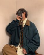 Dark green korean college jacket worn by a person, preppy style.
