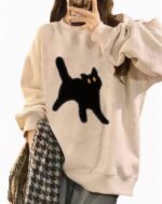 Oversize cat graphic sweater in beige with a black cat design.