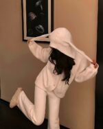 Woman wearing fluffy bunny pajamas with a hood and matching pants.