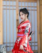 Woman wearing a red short floral kimono with intricate floral design and frills. Japanese aesthetic.