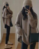 Woman wearing a beige korean style sweater with a knit hat and leggings, casual winter outfit.
