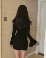 Black gothic aesthetic dress with flared sleeves, back view.