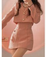 Pink retro aesthetic suit with tweed texture and button details.