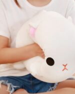 Close-up of a white Kawaii milk cat plushie with black eyes and pink nose.