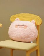 Pink kawaii animal plushie cushion on a wooden chair.