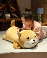 Cute Shiba and husky plushie lying on a bed, soft and cuddly.