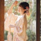 Woman wearing a Hanabi Pattern Summer Yukata dressing, featuring a traditional Japanese design.