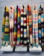 Multiple fluffy kawaii rainbow scarves in various colors and tassels.