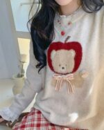Cream-colored cottagecore bear sweater featuring an apple and bow details.