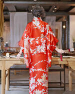 Red satin japanese floral kimono with intricate design, featuring a traditional wrap closure.