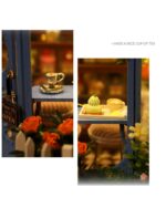 Close-up of a miniature tea house kit featuring tiny tea sets and decorations within the building.