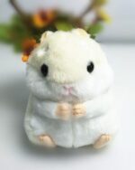 Close-up of a white kawaii chibi hamster plushie with black eyes and a pink nose.