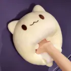 A beige round neko plushie with stitched eyes and mouth.