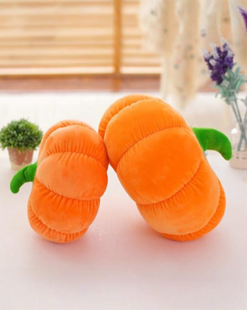Two plush pumpkin cushions, orange and green, serving as aesthetic room decor.