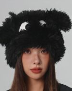 Black fluffy eyed hat on a woman's head. A cute, whimsical fluffy eyed hat.