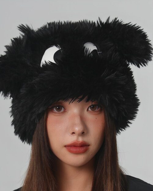 Black fluffy eyed hat on a woman's head. A cute, whimsical fluffy eyed hat.