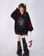 Black loose gothic sweater featuring a spider web design and long sleeves. A stylish gothic fashion item.