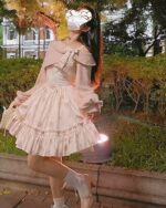 A pink floral soft girl dress with ruffles, bow, and lace details, worn outdoors.