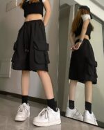 Black Korean aesthetic shorts with multiple pockets, styled with a crop top and sneakers.