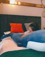 Blue kawaii whale plushie resting on a bed, perfect for cuddling.