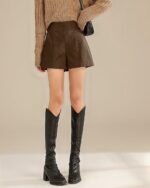 Brown vegan leather high waist shorts with a vintage aesthetic, paired with boots.