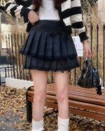 Black laced pleated korean aesthetic skirt with a gathered tulle overlay. Details include a bow and delicate netting.