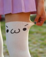 Kawaii Japanese kaomoji stockings with a smiling face design on the knee.