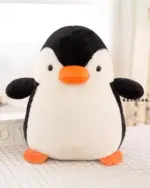 A soft, black and white chonky penguin plushie with orange feet and beak.