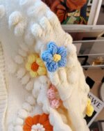 Handmade aesthetic cardigan with crocheted flower embellishments.