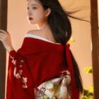 A woman wearing a red aesthetic kimono with floral details and intricate patterns.