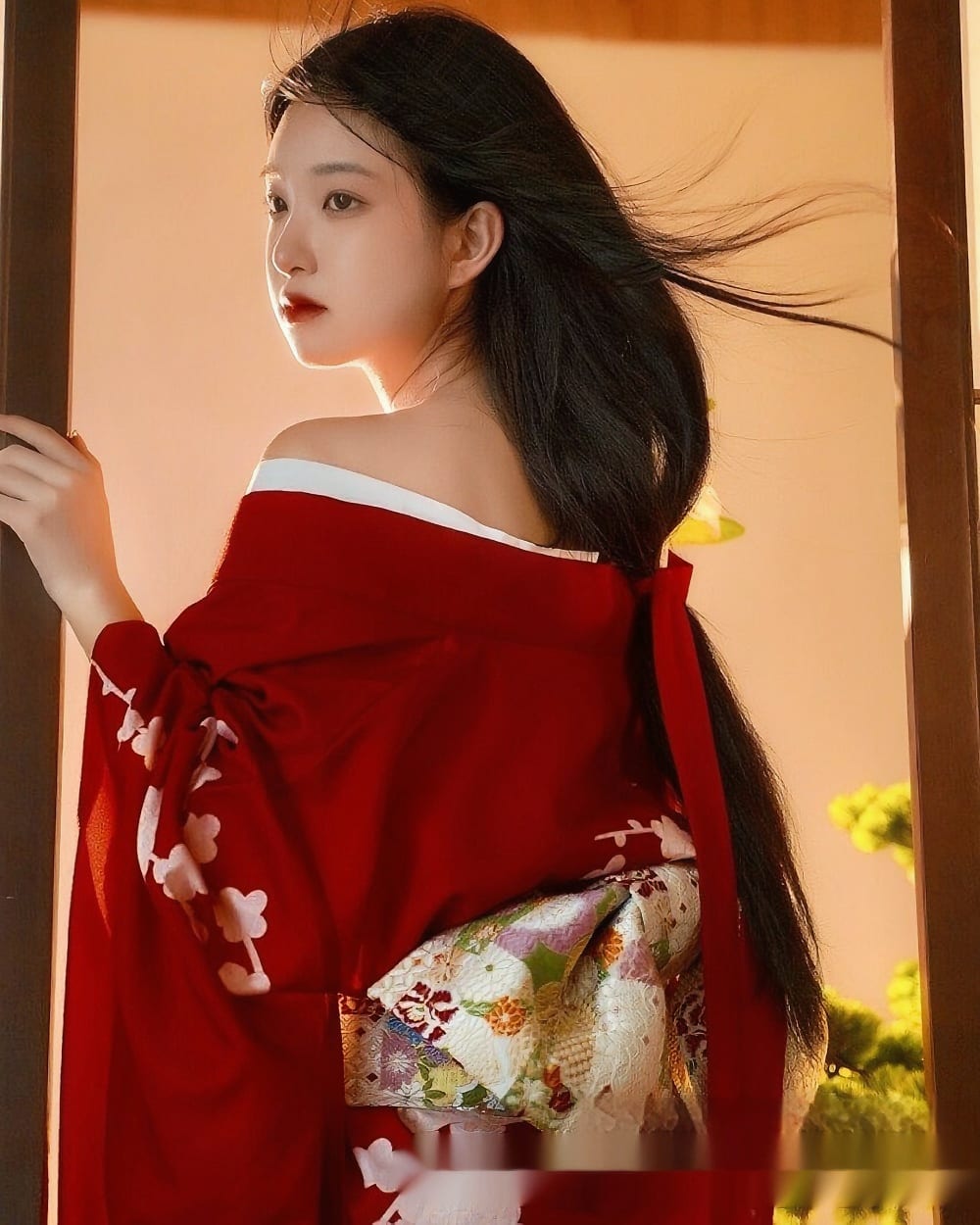 A woman wearing a red aesthetic kimono with floral details and intricate patterns.