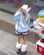 Woman wearing a loose thick feathered harajuku hoodie and matching accessories.