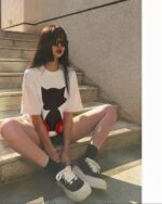 Woman wearing an astro silhouette t-shirt and platform sneakers.