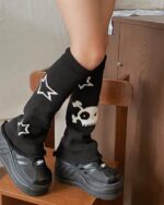 Black gyaru leg warmers with gothic star and skull designs covering the legs.