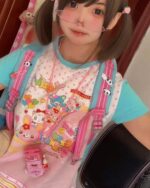 Model wearing a Kawaii Pastel Mezzo Piano T-Shirt with a colorful character design.