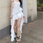 White ruffled sling dress with a high slit, showcasing a coquette aesthetic.