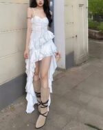 White ruffled sling dress with a high slit, showcasing a coquette aesthetic.