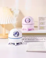 Kawaii Mini Spaceship Humidifier, an astronaut humidifier, on a desk with a lamp and books.