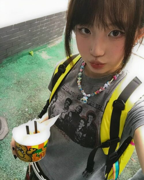 Person wearing a retro grunge t-shirt with The Beatles graphic outdoors.