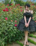 A black gothic lolita dress set, featuring ruffles and lace, worn outdoors.