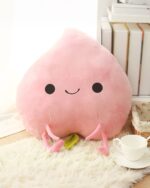 Pink kawaii fruit plushie with black eyes, a smile, and small arms on a white surface.