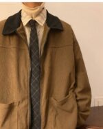 Close-up of a brown corduroy korean college jacket with a zipper and collar detail.