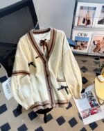 Cream kawaii bow sweater with a tie neckline and ribbed detailing.